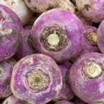 a pile of purple turnips sitting next to each other